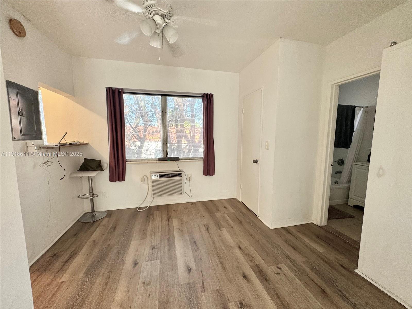 4740 Pine Tree Drive, Unit 32 Miami Beach, FL 33140 - Photo 10 of 20 a view of a room with wooden floor a ceiling fan and windows