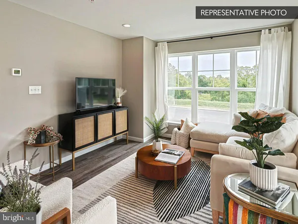 a living room with furniture a flat screen tv and a large window