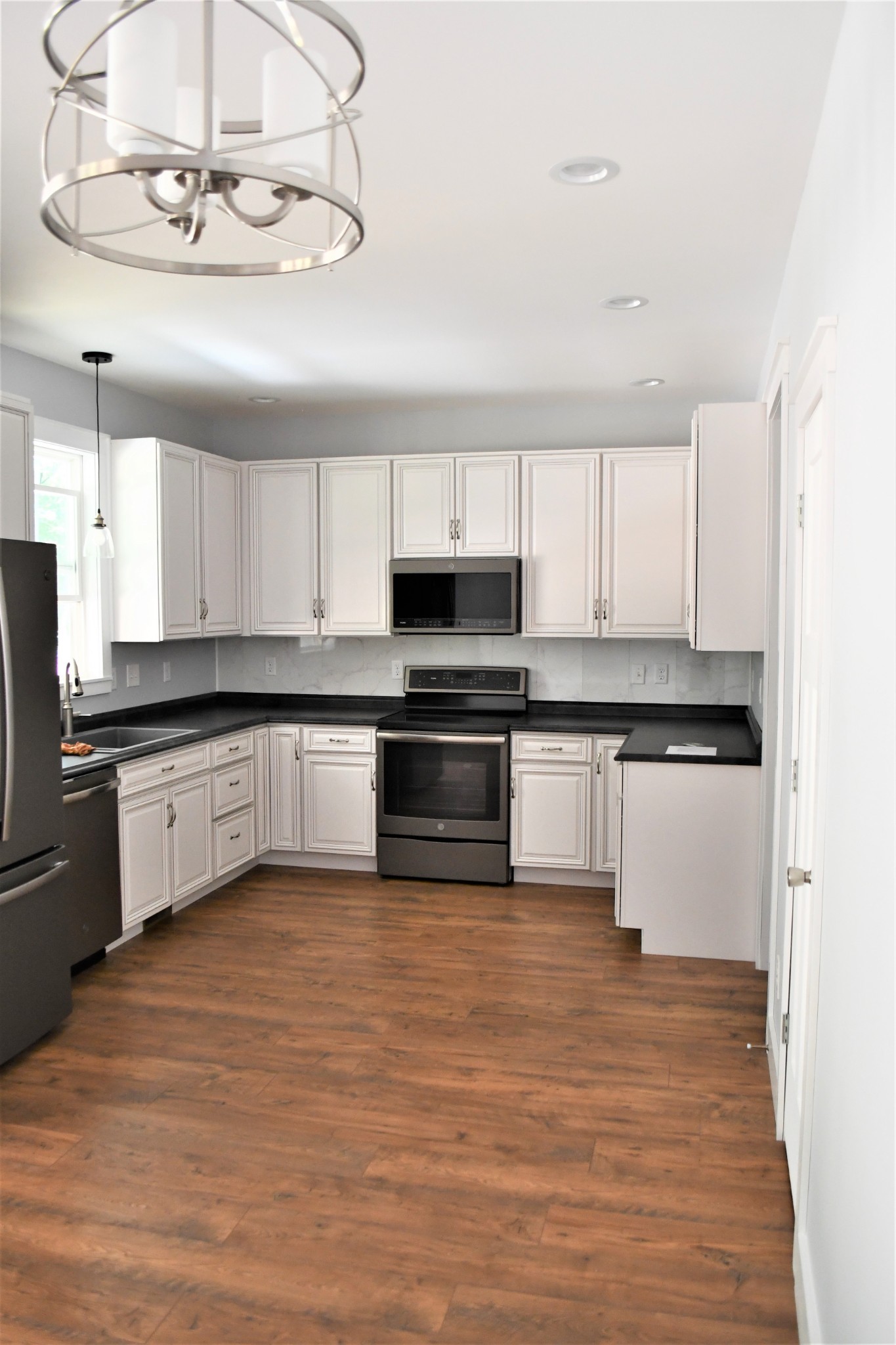 1387 Cooley's Rift Boulevard Monteagle, TN 37356 - Photo 14 of 24 a kitchen with granite countertop a refrigerator and white cabinets