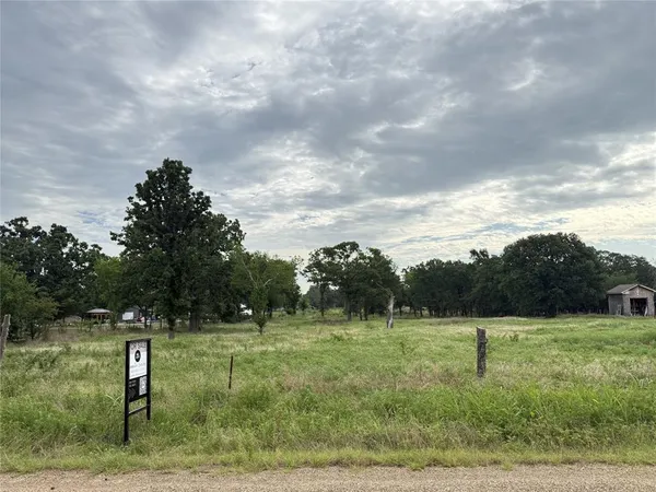 a view of a green field with wooden fence