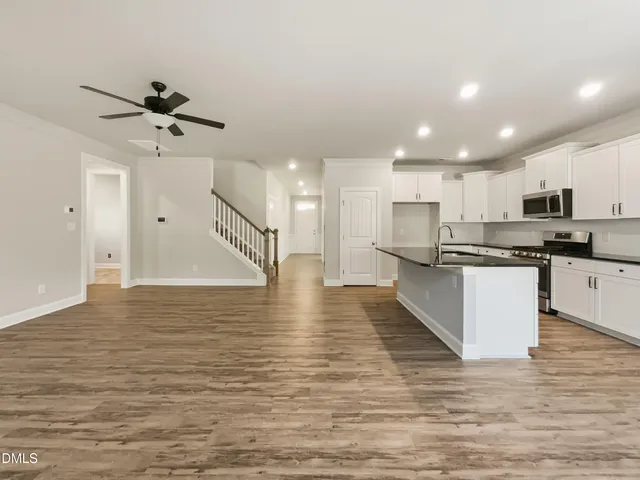 a view of kitchen with kitchen island microwave oven a sink and white cabinets