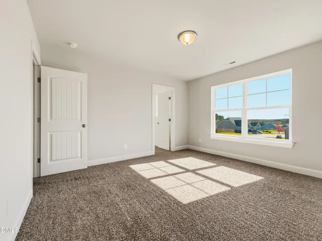 an empty room with windows and mirror