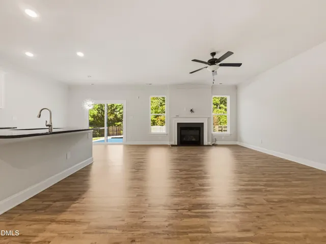 a view of empty room with a fireplace and wooden floor