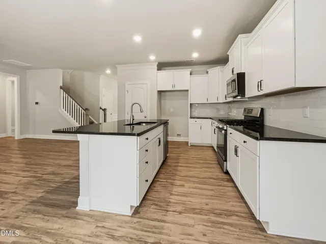 a kitchen with stainless steel appliances granite countertop a sink and cabinets