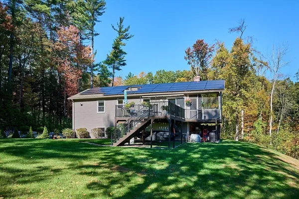 a kitchen with stainless steel appliances granite countertop a stove a sink a microwave a dining table and chairs with wooden floor