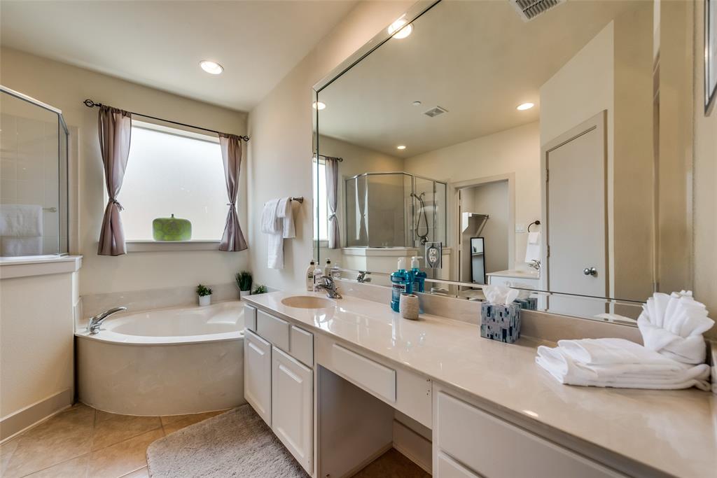 2718 Floyd Street Dallas, TX 75204 - Photo 8 of 25 a bathroom with a double vanity sink a mirror and a bathtub