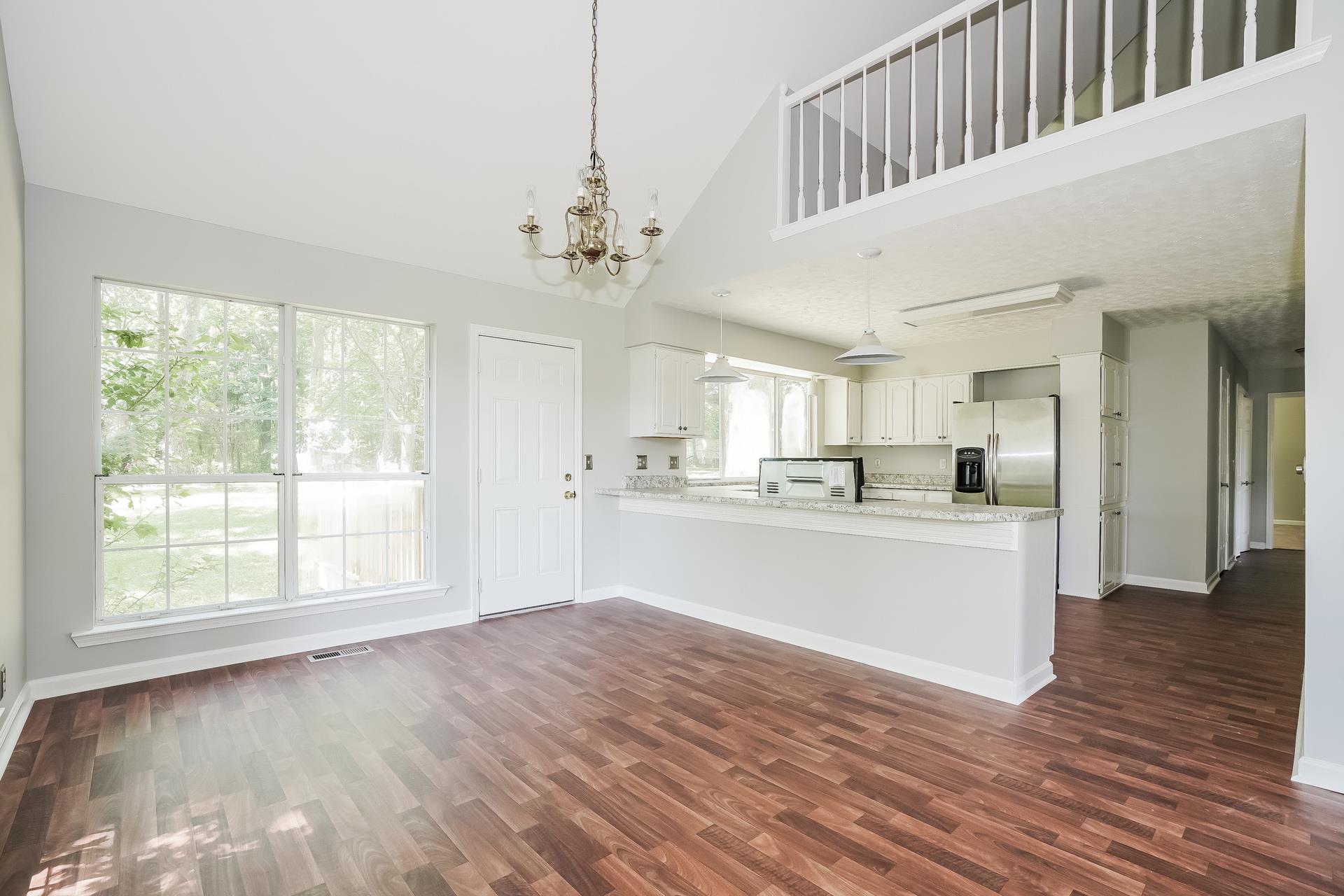 207 Independence Street Springfield, TN 37172 - Photo 13 of 25 a view of an empty room and kitchen with wooden floor