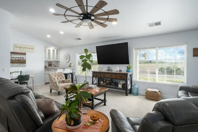 a living room with furniture a flat screen tv and a large window