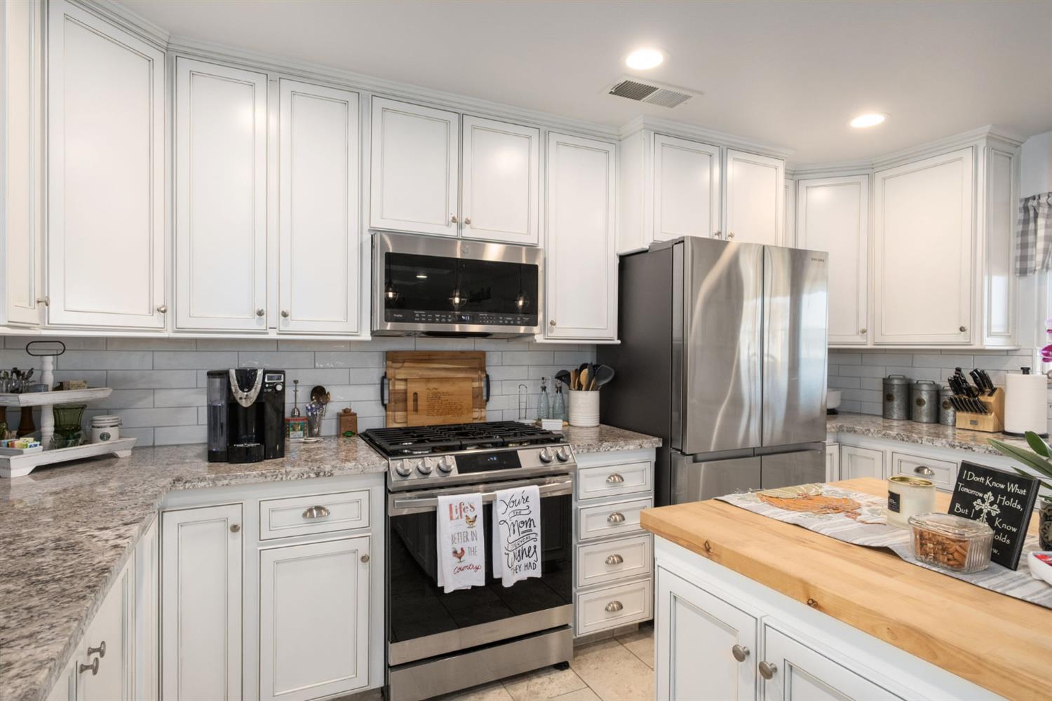 17534 West Lacey Boulevard Lemoore, CA 93245 - Photo 19 of 49 a kitchen with refrigerator a stove a sink a refrigerator and cabinets