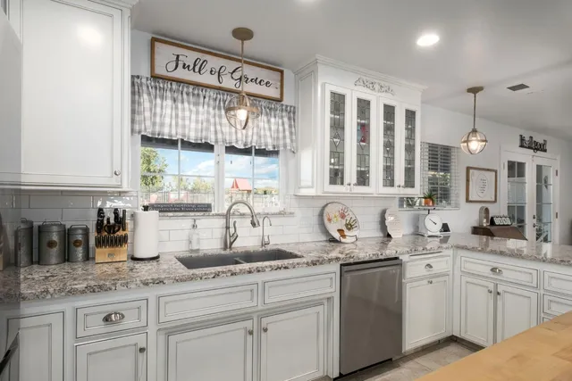a kitchen with granite countertop a sink and cabinets