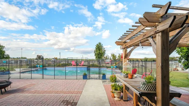 a view of a swimming pool with a patio and a yard