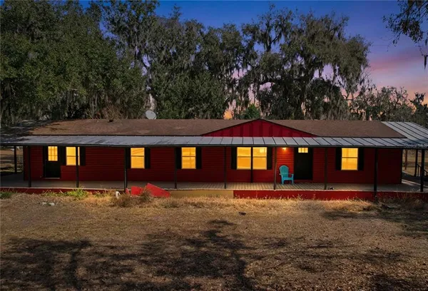 an aerial view of a house with a yard and trees