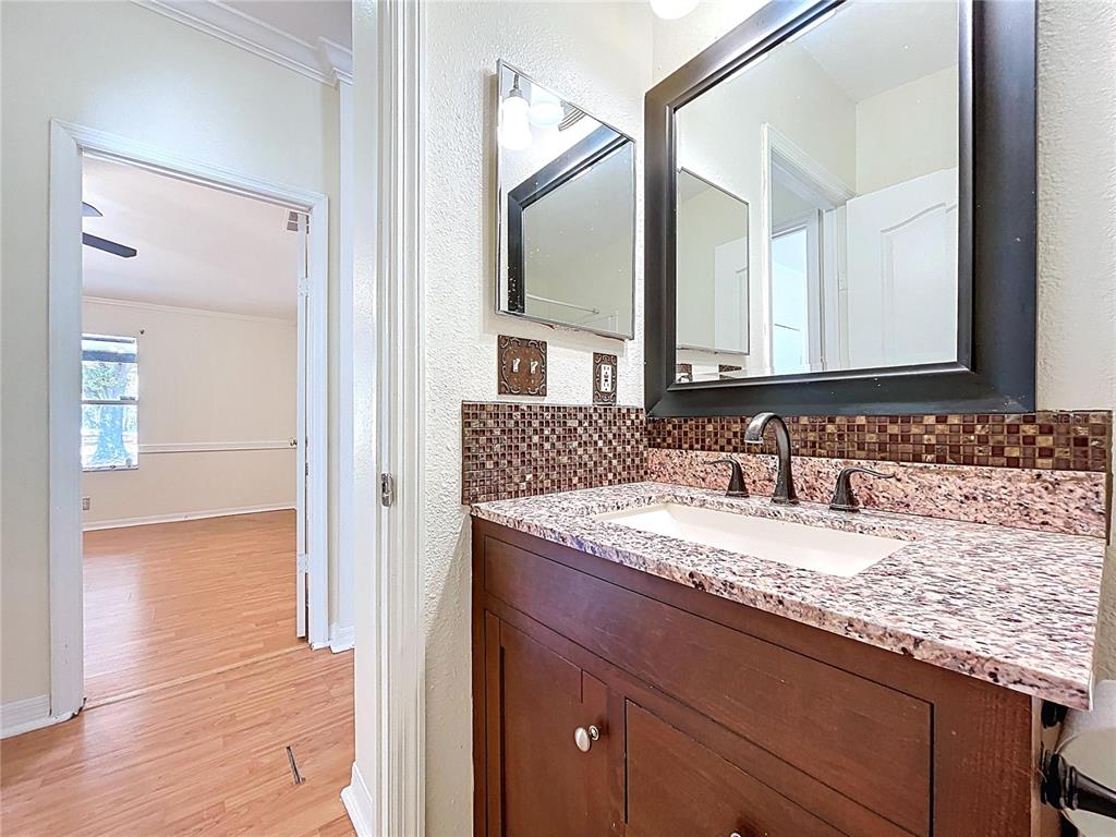 15210 Rough Diamond Ranch Road Lithia, FL 33547 - Photo 57 of 76 a bathroom with a granite countertop sink and a mirror