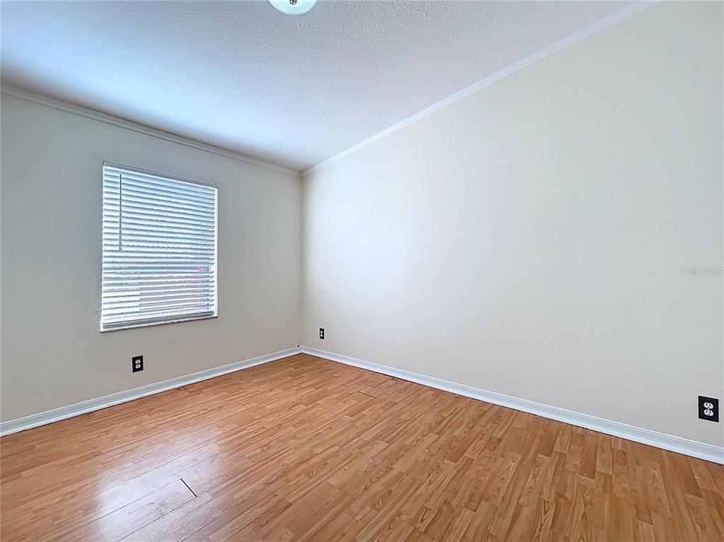 15210 Rough Diamond Ranch Road Lithia, FL 33547 - Photo 61 of 76 an empty room with wooden floor and windows