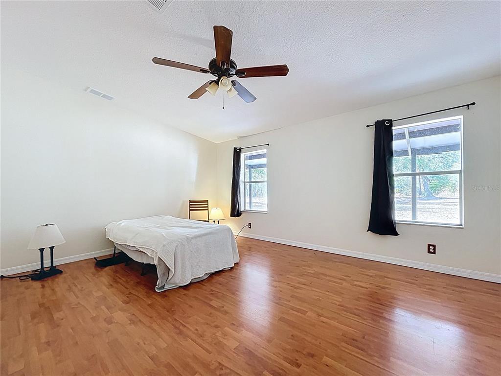 15210 Rough Diamond Ranch Road Lithia, FL 33547 - Photo 63 of 76 a bedroom with a bed and wooden floor