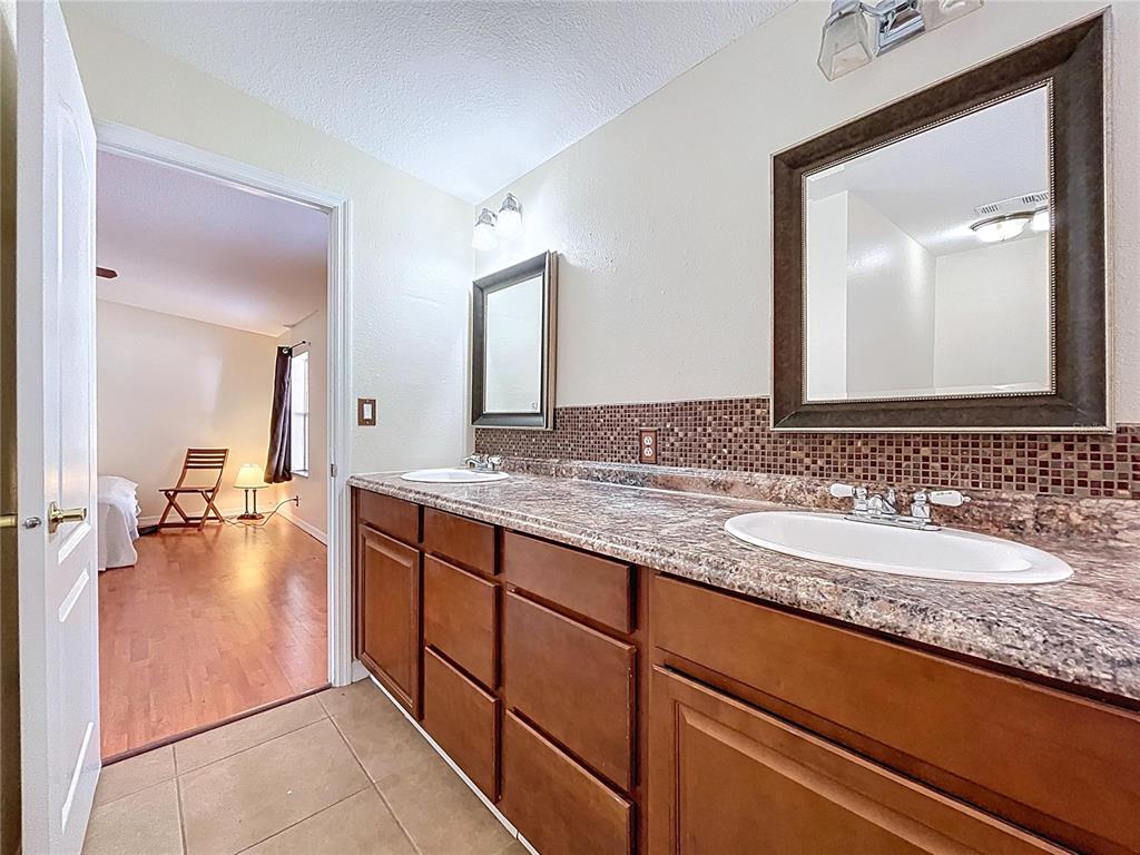 15210 Rough Diamond Ranch Road Lithia, FL 33547 - Photo 67 of 76 a bathroom with a granite countertop sink and a mirror