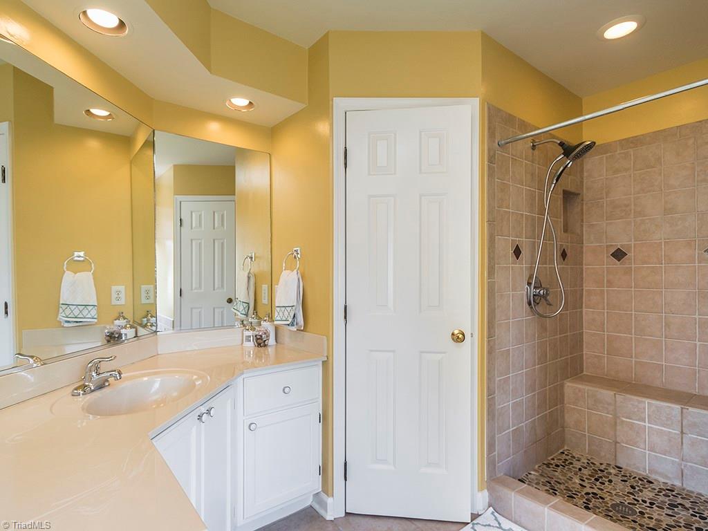 3101 Spring Mill Road Greensboro, NC 27406 - Photo 15 of 30 Incredibly well done master bath, take a look at the unique look of the floor of the shower. Separate garden tub not pictured. Also note the counter space! And seperate water closet.