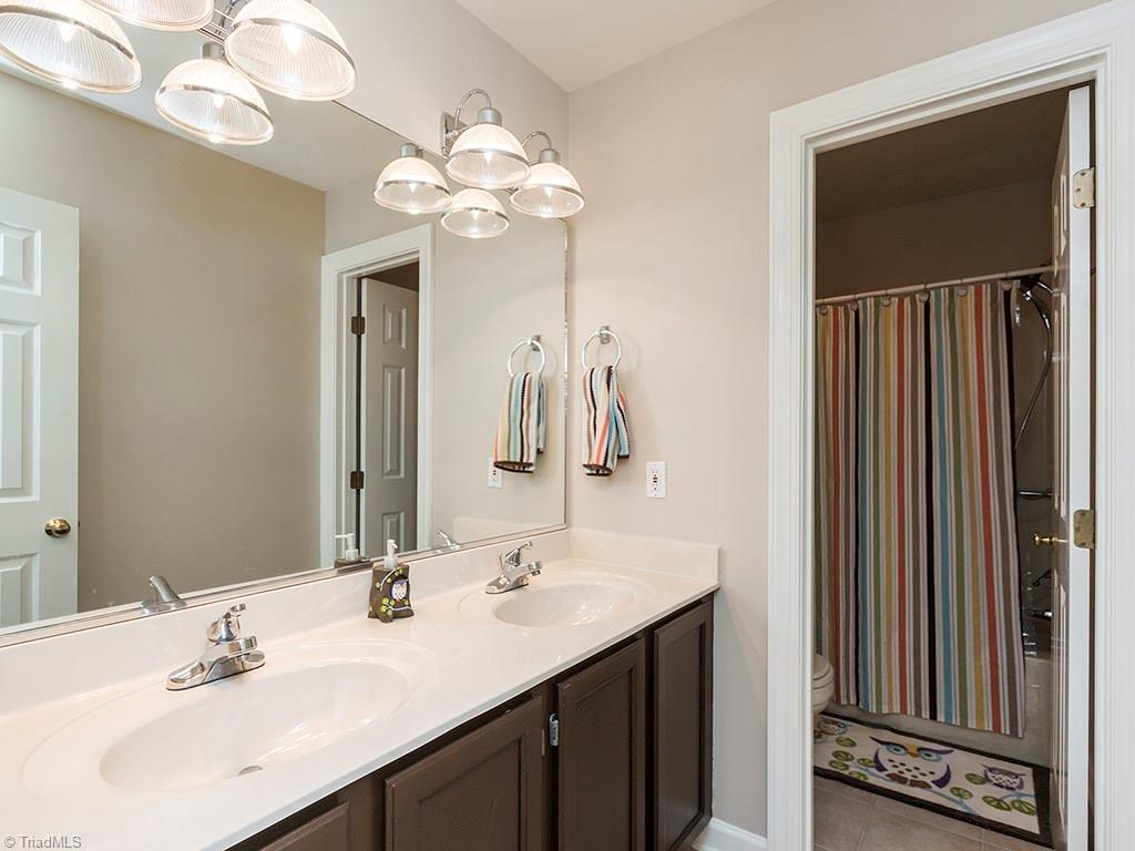 3101 Spring Mill Road Greensboro, NC 27406 - Photo 18 of 30 Double vanity sink in second bath with separate door for bath/shower, making getting ready in the morning easier for guests or kids.