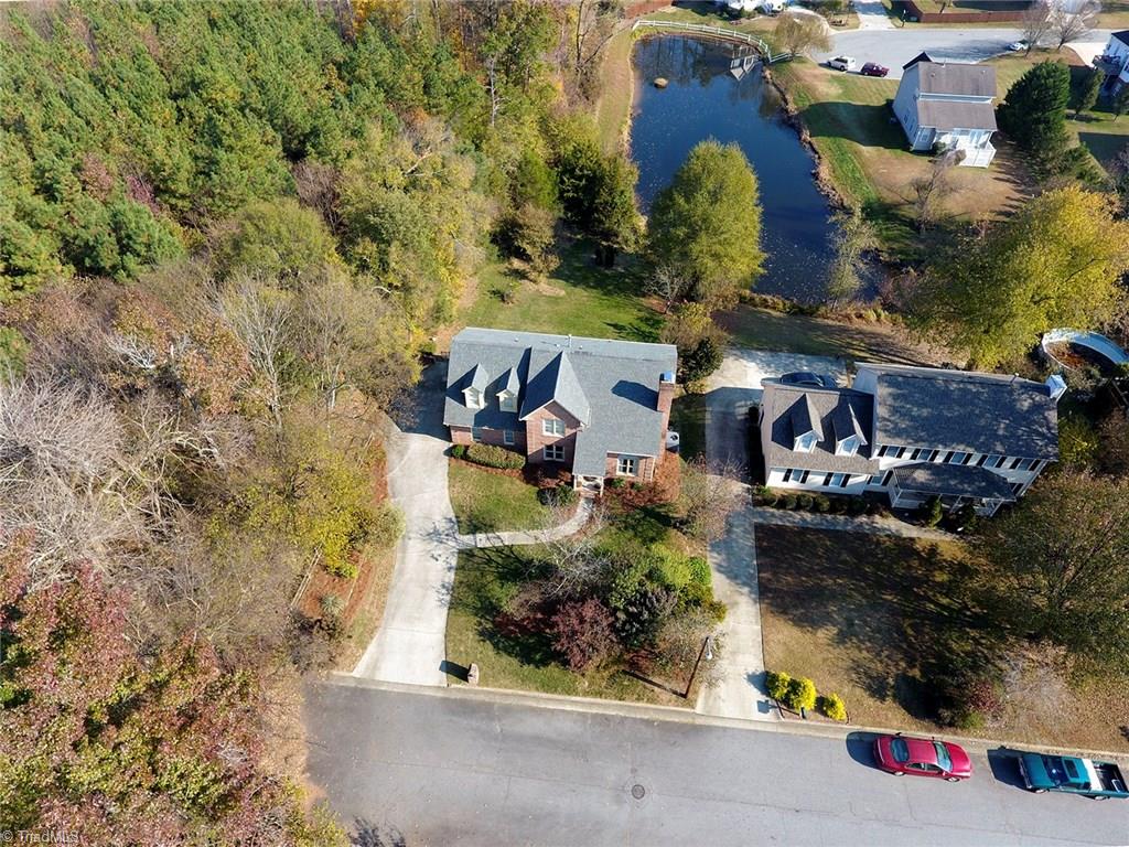 3101 Spring Mill Road Greensboro, NC 27406 - Photo 3 of 30 Pond view can really be seen here as well as how lush and private it is with the dense woods to the left of the home.