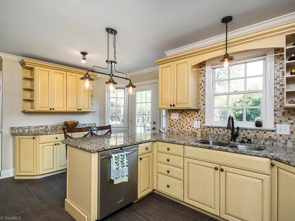 3101 Spring Mill Road Greensboro, NC 27406 - Photo 4 of 30 Updated kitchen with trending edison bulb light fixtures. Granite with tile backsplash. Fashionable antique bronze throughout kitchen.