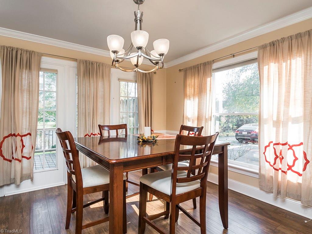 3101 Spring Mill Road Greensboro, NC 27406 - Photo 8 of 30 Dining Room with light airy feel with the almost floor to ceiling windows. Updated light fixture. Notice the crown molding and large base molding adding to the classic design of this room.