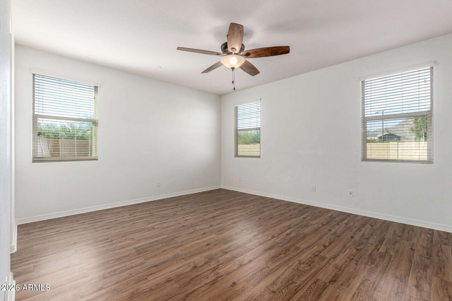 21294 West Berkeley Road Buckeye, AZ 85396 - Photo 13 of 34 a view of an empty room with wooden floor and a window