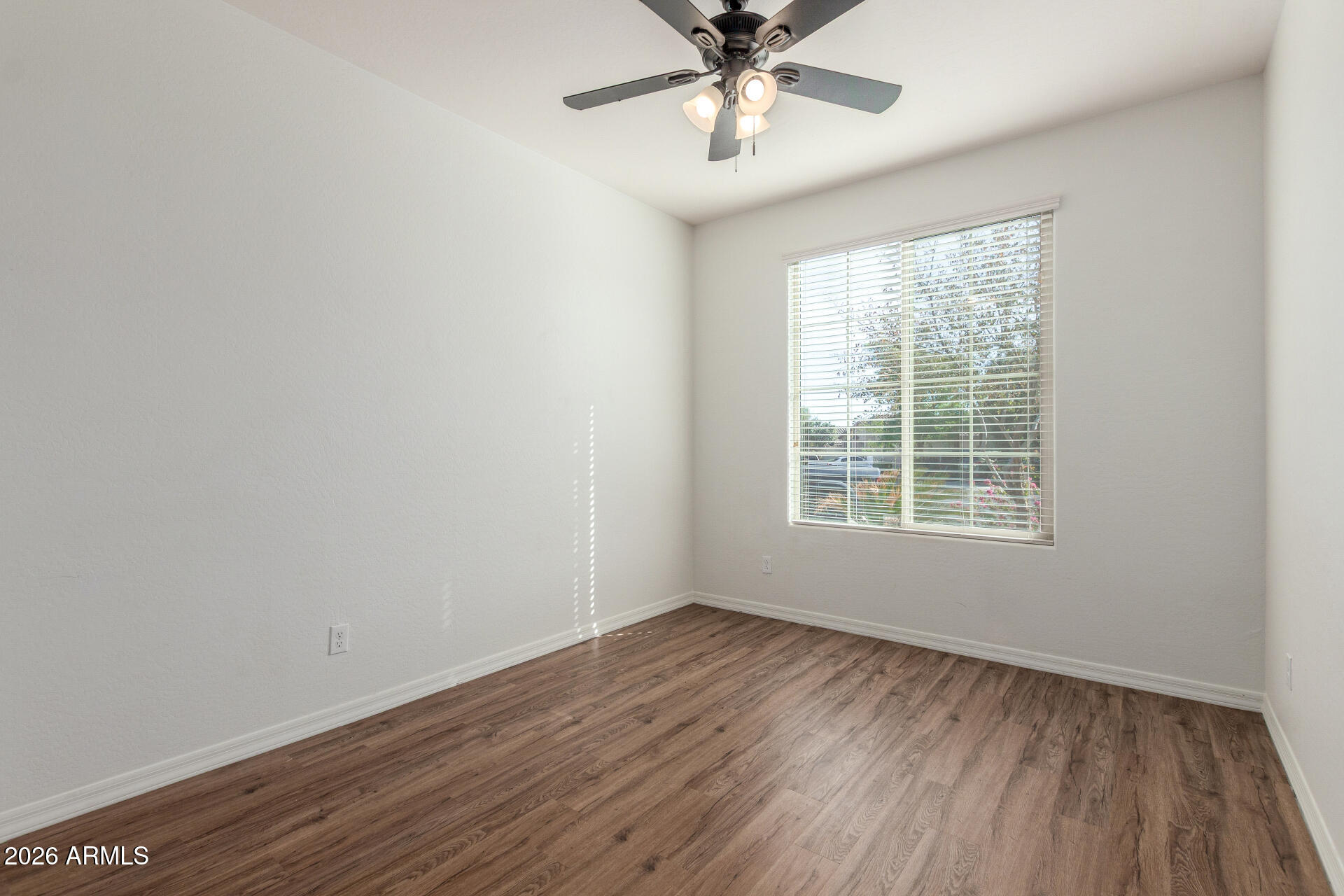 21294 West Berkeley Road Buckeye, AZ 85396 - Photo 19 of 34 a view of an empty room with wooden floor and a window