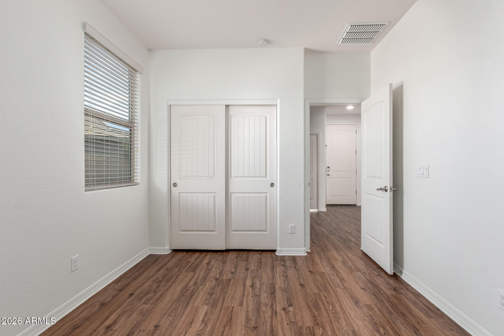 21294 West Berkeley Road Buckeye, AZ 85396 - Photo 22 of 34 an empty room with wooden floor and windows