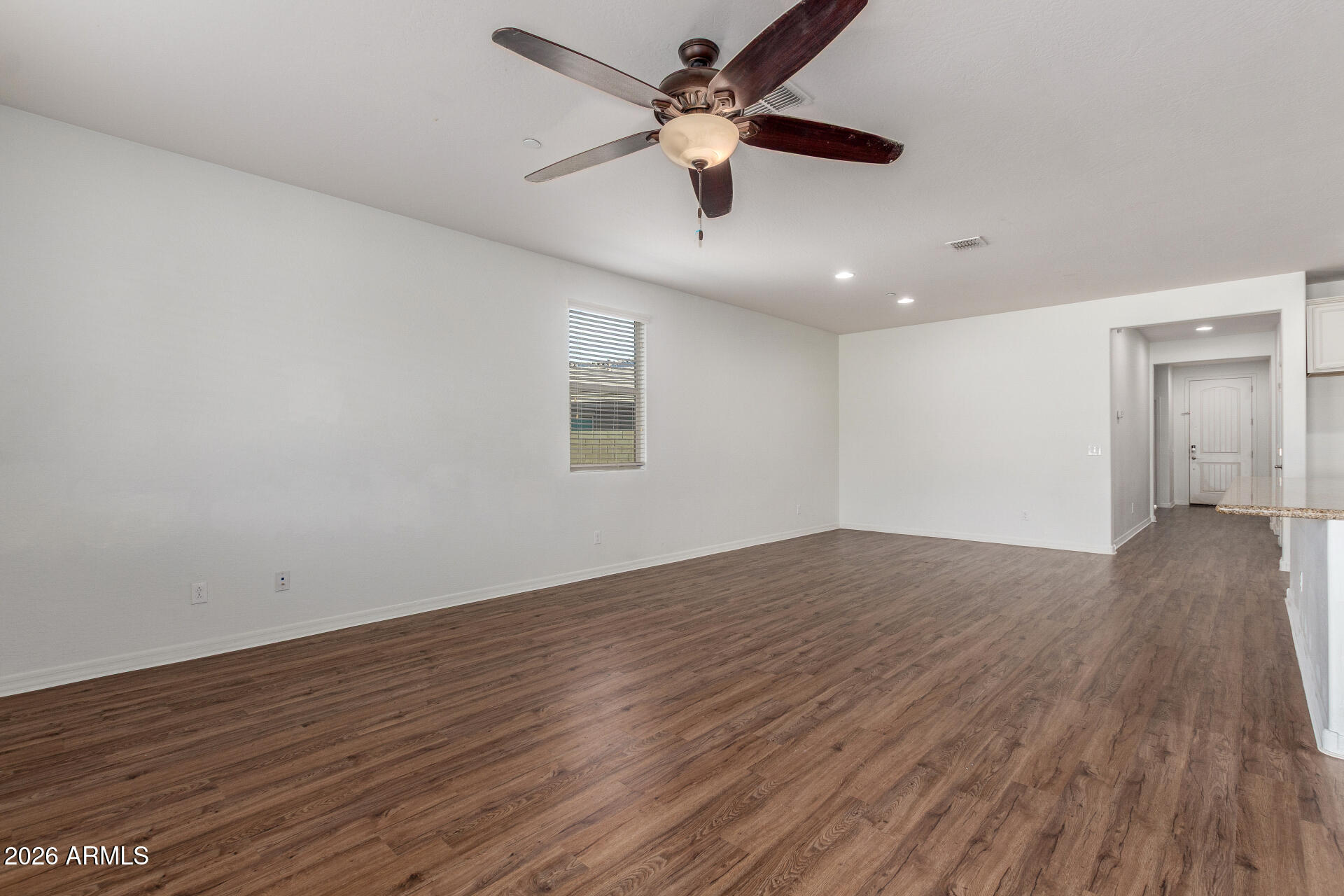 21294 West Berkeley Road Buckeye, AZ 85396 - Photo 4 of 34 an empty room with wooden floor and windows