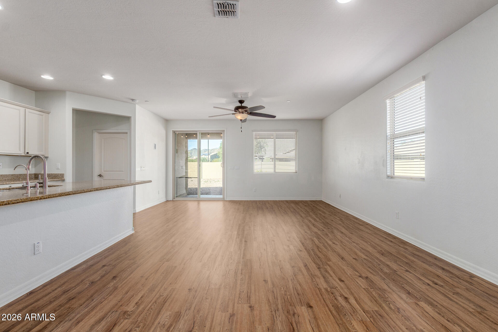 21294 West Berkeley Road Buckeye, AZ 85396 - Photo 5 of 34 a view of an empty room with wooden floor and a window
