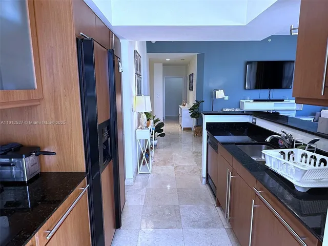 a kitchen with kitchen island granite countertop a sink and a stove
