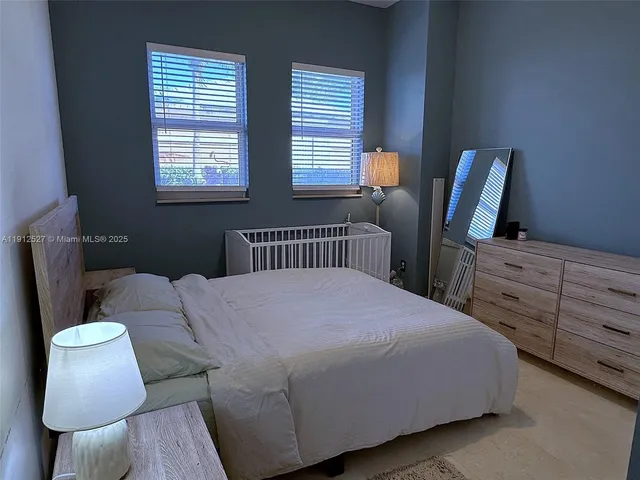 a bedroom with a bed a chair and dresser