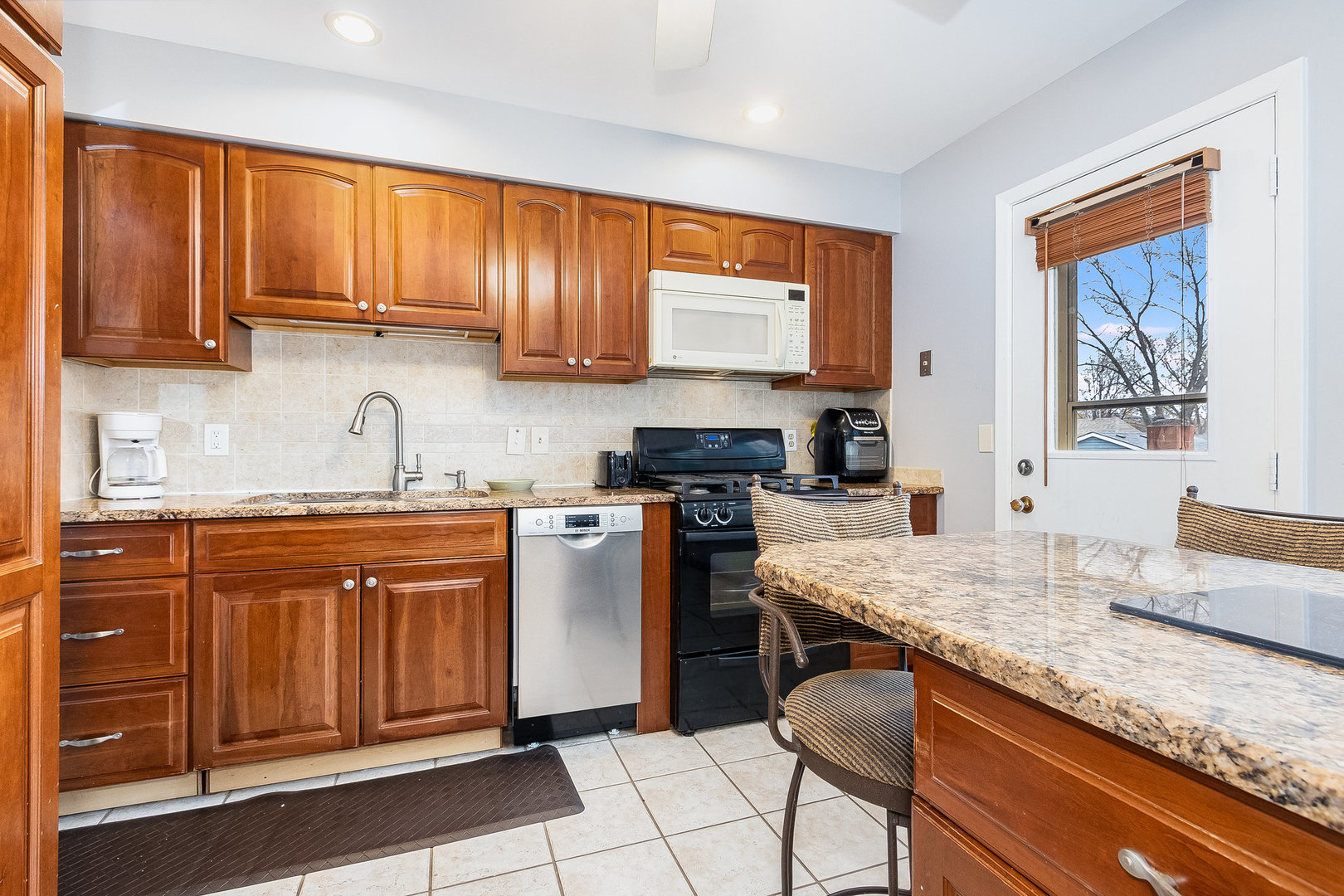 36 Field Point Road Montgomery, IL 60538 - Photo 4 of 28 a kitchen with granite countertop wooden cabinets a sink and dishwasher