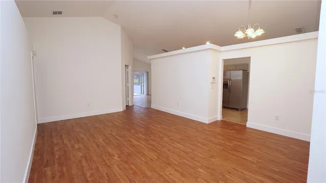 a view of a room with wooden floor and white walls