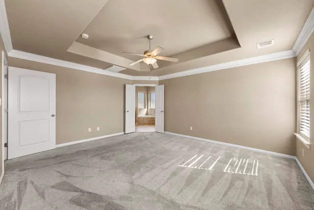 a view of an empty room with a chandelier fan