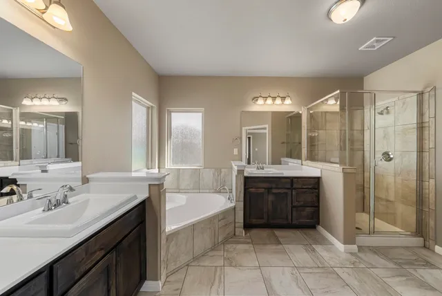 a bathroom with a tub sink shower and mirror