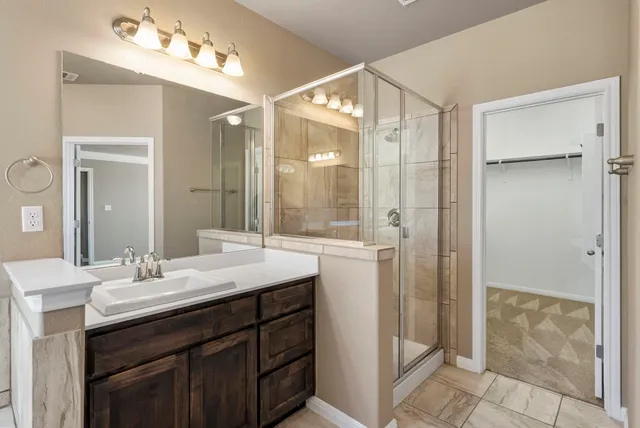 a bathroom with a shower sink and mirror