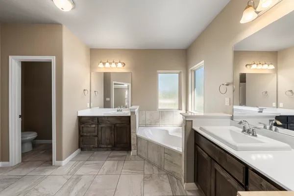 a spacious bathroom with a bathtub sink mirror and toilet