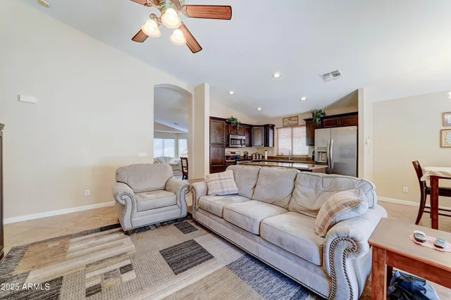 a living room with furniture and a view of kitchen