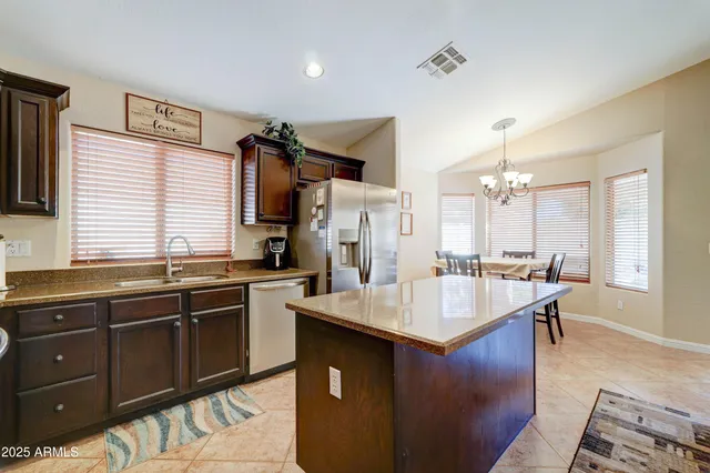 a kitchen with stainless steel appliances granite countertop a sink a stove and refrigerator