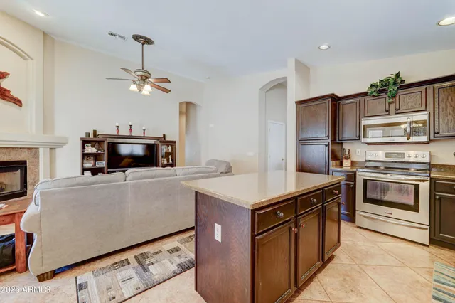 a kitchen with kitchen island a counter top space stainless steel appliances and a chandelier