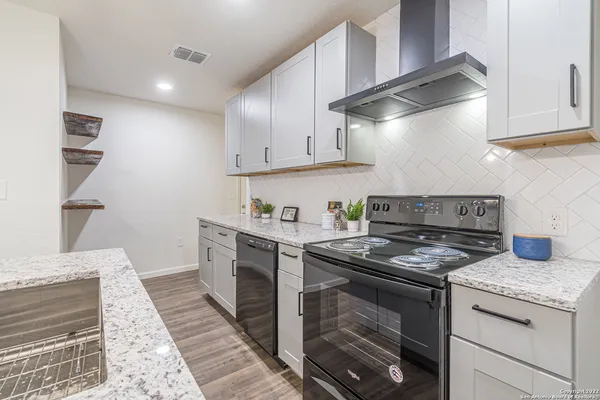 a kitchen with stainless steel appliances granite countertop a stove and a cabinets