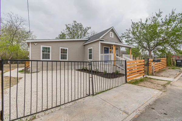 a view of a house with a small yard and wooden fence
