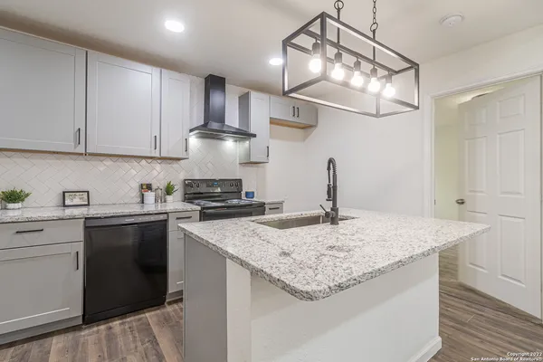 a kitchen with a sink a stove and cabinets