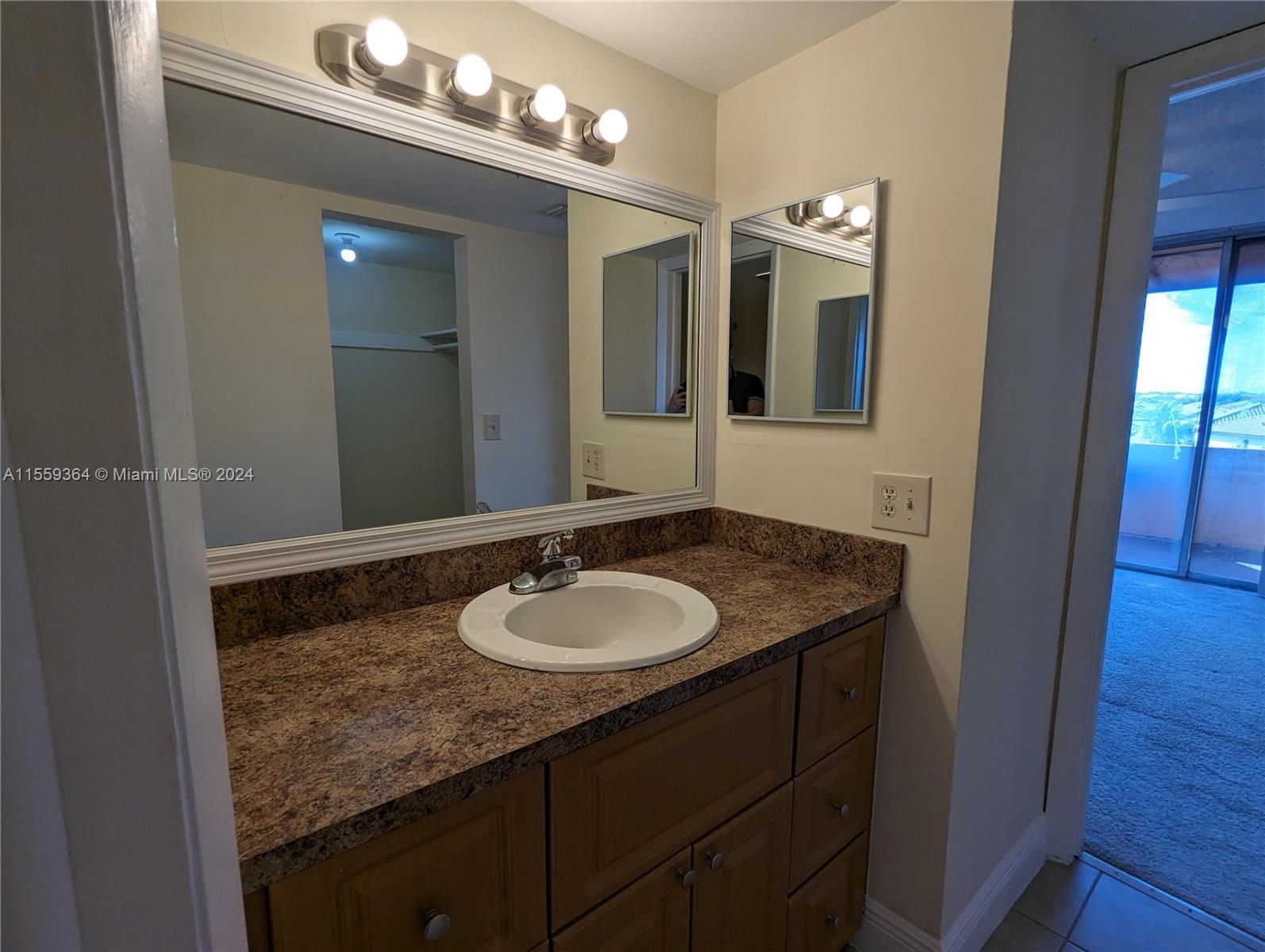 3490 Foxcroft Road, Unit B310 Miramar, FL 33025 - Photo 18 of 34 a bathroom with a granite countertop sink and a mirror