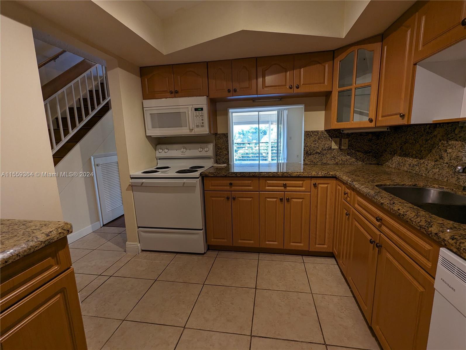 3490 Foxcroft Road, Unit B310 Miramar, FL 33025 - Photo 5 of 34 a kitchen with a sink a stove and cabinets