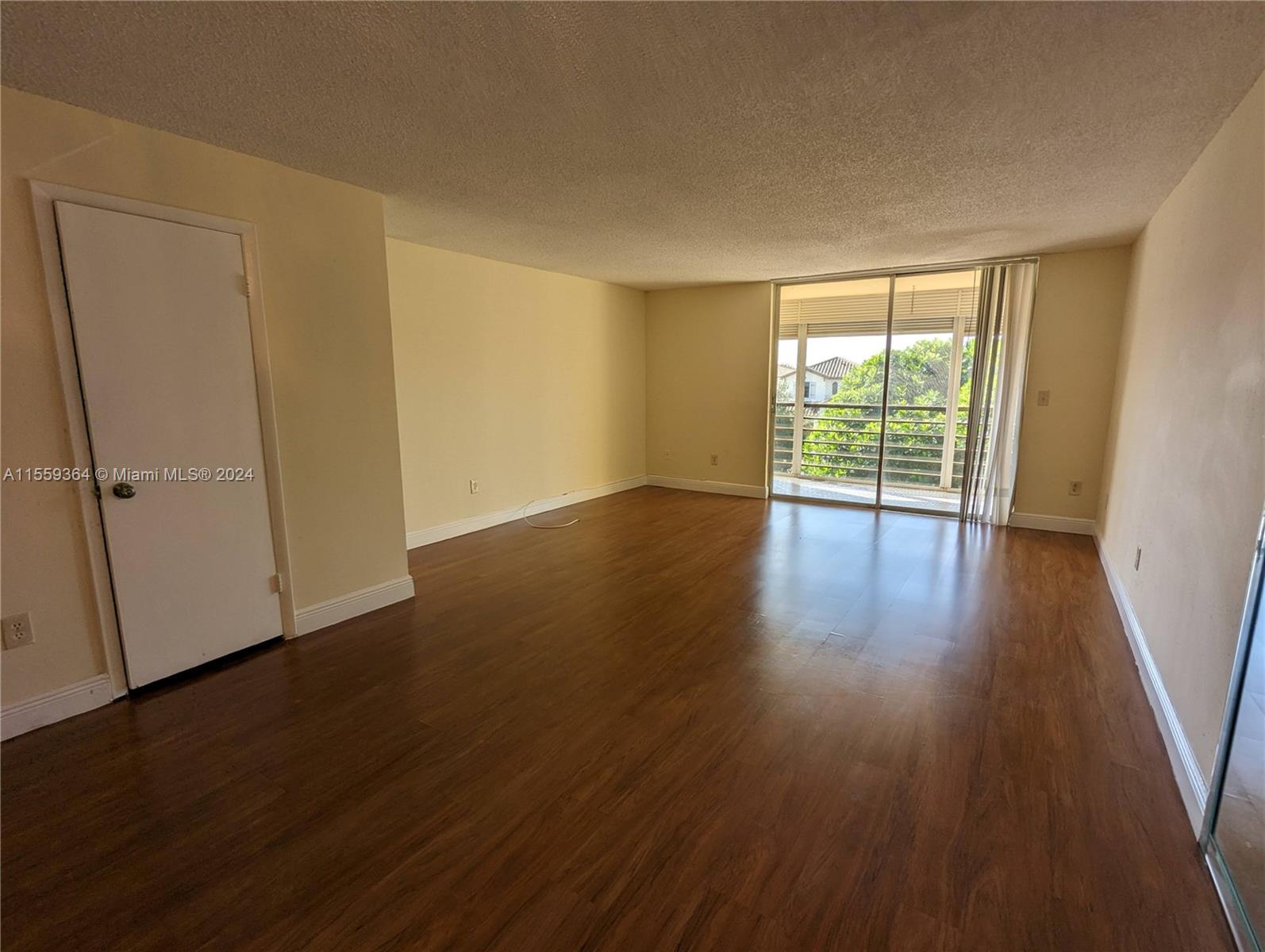 3490 Foxcroft Road, Unit B310 Miramar, FL 33025 - Photo 10 of 34 a view of an empty room with wooden floor and a window