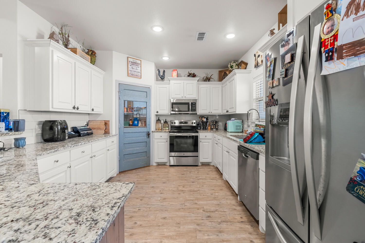 542 Nora Road Wilson, TX 79381 - Photo 21 of 42 a kitchen with stainless steel appliances granite countertop a refrigerator and a stove top oven