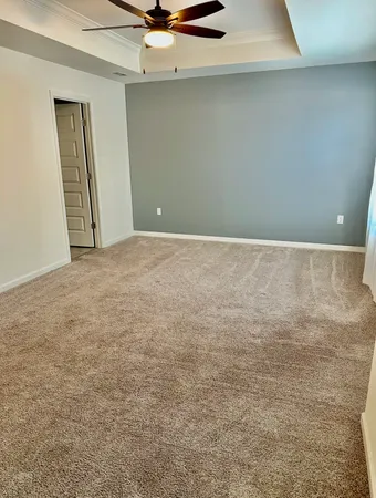 an empty room with a ceiling fan and window