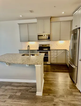 a kitchen with stainless steel appliances granite countertop a refrigerator a stove a sink and a microwave